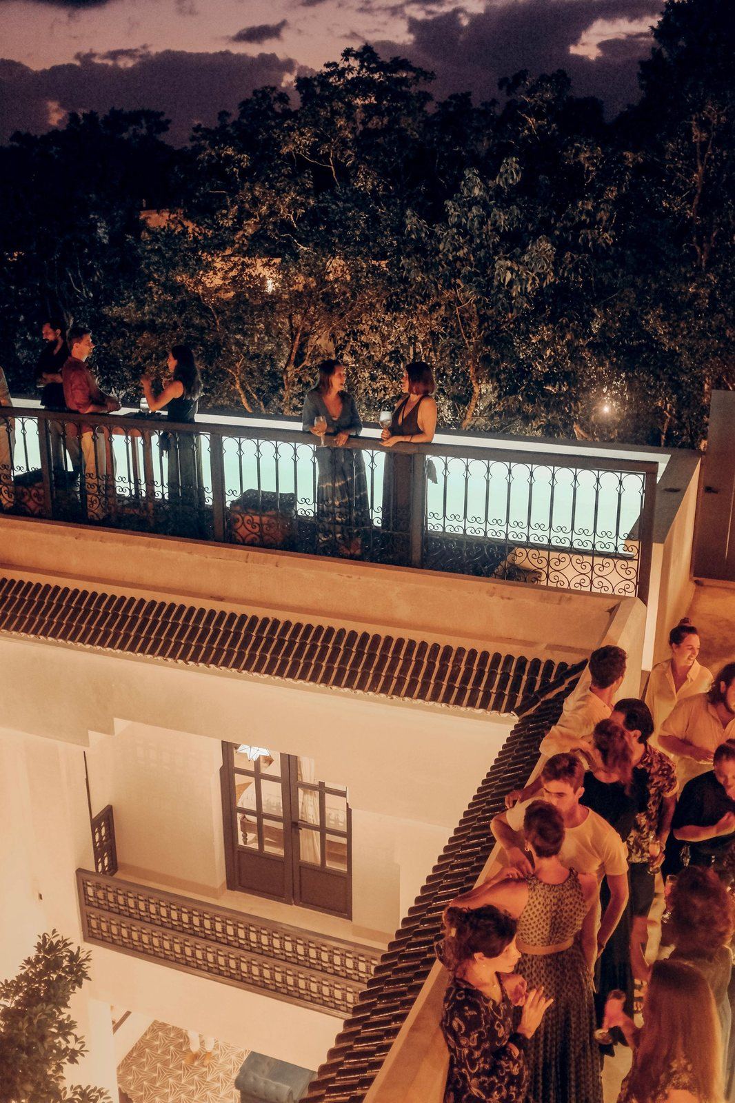 Guests with drinks on the rooftop at dusk