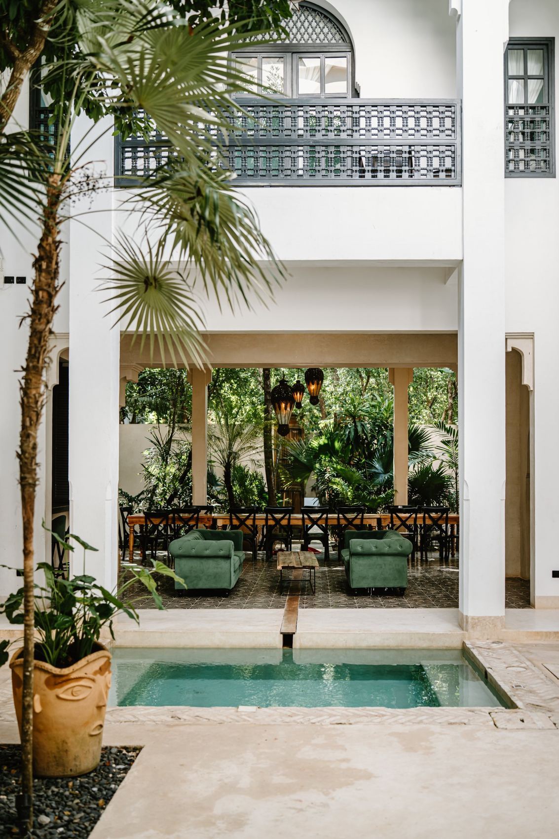 Covered terrace with sofas and a long table