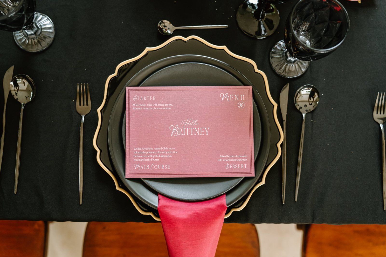 Black place setting with a burgundy menu